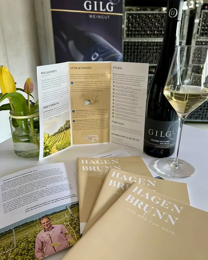 Flyer für Hagenbrunn der Weg zum Wein, eine Falsche und ein Glas mit Grünem Veltliner von GILG